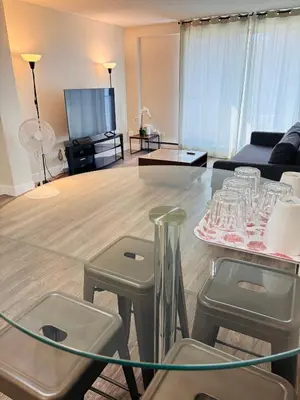 a living room with a glass table and stools at Cozy 1 Bedroom Condo with Parking in Calgary