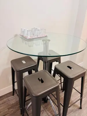 a glass table with two stools and a glass table at Cozy 1 Bedroom Condo with Parking in Calgary
