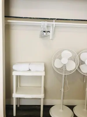 a white room with a table and a fan at Cozy 1 Bedroom Condo with Parking in Calgary