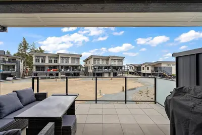 a large patio with a view of a volleyball court at The Beach House at Saratoga Modern Beach Oasis in Oyster Bay