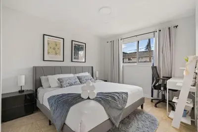 a bedroom with a bed with a desk and a window at Spacious 4-Bedroom Retreat Near Bow River with Foosball, Dart Board, Movie Room in Calgary