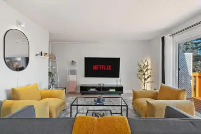 a living room with yellow chairs and a tv at Spacious 4-Bedroom Retreat Near Bow River with Foosball, Dart Board, Movie Room in Calgary