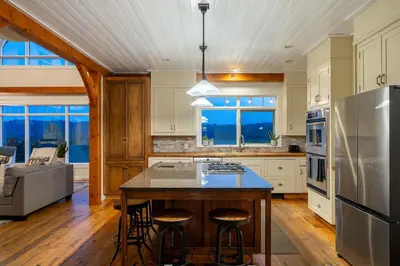 a kitchen with a center island with bar stools at Rolling Hills Retreat - Family Friendly in Millarville
