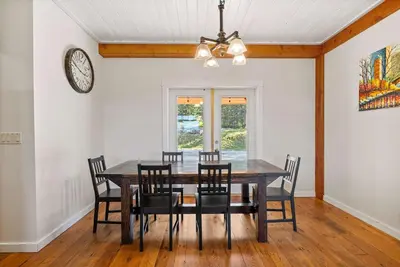 a dining room with a table and chairs and a clock at Rolling Hills Retreat - Family Friendly in Millarville