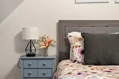 a bedroom with a bed with a lamp and a nightstand at Rolling Hills Retreat - Family Friendly in Millarville