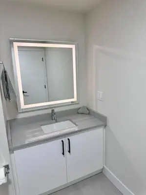 a bathroom with a sink and a mirror at Charming & Compact Retreat in St. Albert