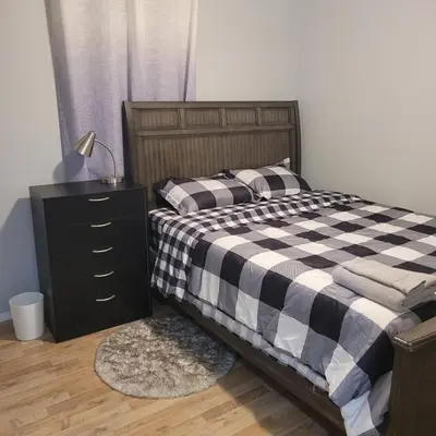 a bedroom with a black and white checkered bed and a dresser at Fabulous Room in Edmonton
