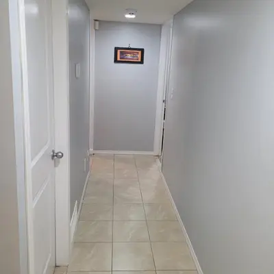 a hallway with a white door and a tile floor at Fabulous Room in Edmonton