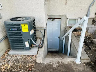 a building with a heat pump next to a door at Walkout Basement Suite with Free Street Parking in Calgary