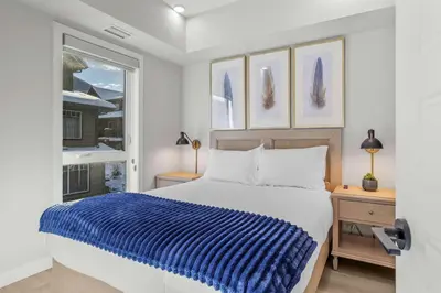 a white bedroom with a bed and a window at Outdoor heated pool and hot tub Stunning 3Bd sanctuary in Dead Man's Flats