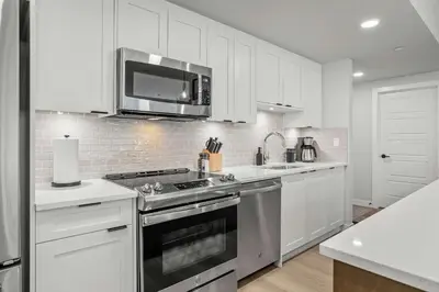 a white kitchen with a stove and a microwave at Outdoor heated pool and hot tub Stunning 3Bd sanctuary in Dead Man's Flats