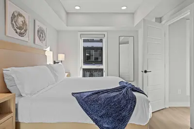 a bedroom with a white bed with a blue blanket on it at Outdoor heated pool and hot tub Stunning 3Bd sanctuary in Dead Man's Flats