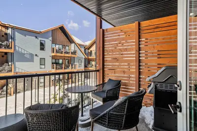 a balcony with a table and chairs and a fence at Pool and hot tub Stunning 2Bd haven in the Rockies in Dead Man's Flats