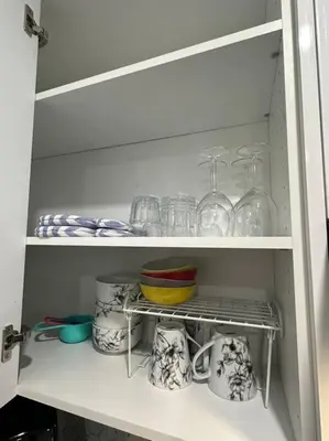 a white cabinet with dishes and glasses on it at The Urban Nest in Calgary