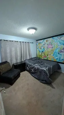 a bedroom with a bed and a couch and a chair at Spacious West Kelowna Home that is great for family, friends, or business trip! in West Kelowna