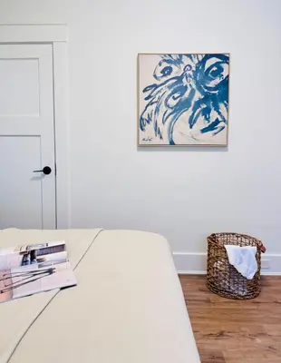 a bedroom with a bed with books and a picture on the wall at Deluxe Queen Room Private Ensuite Vancouver West in Vancouver