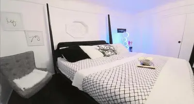 a bedroom with a black and white bed and a chair at Spacious Private Cozy 2br Home with TeePee Dining Room! Private Parking! Self Check-in in Burnaby