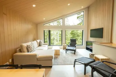 a living room with a couch and a tv at Calmwater Retreat New 2 br Hot Tub in Ucluelet