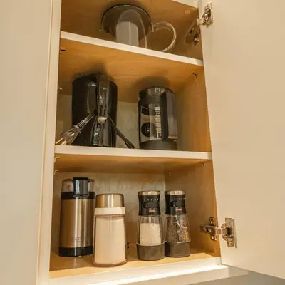 a cupboard filled with coffee cups and appliances at Calmwater Retreat New 2 br Hot Tub in Ucluelet