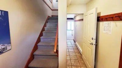 a hallway with a staircase in a house at Timberline Village #46 home in Sun Peaks