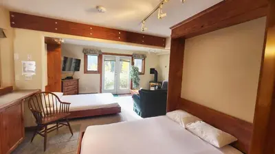 a bedroom with two beds and a living room at Timberline Village #46 home in Sun Peaks