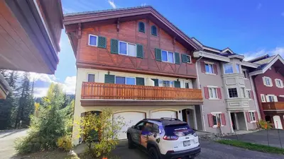 a house with a car parked in front of it at Timberline Village #46 home in Sun Peaks