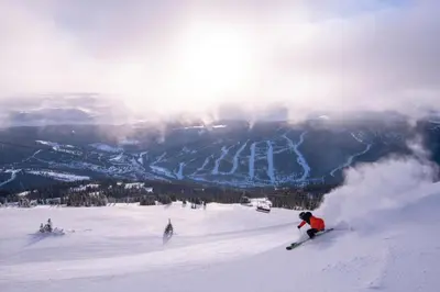 a group of people skiing down a snow covered slope at Timberline Village #46 home in Sun Peaks