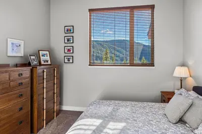 a bedroom with a bed and a dresser and a window at Powder Heights #15 home in Sun Peaks