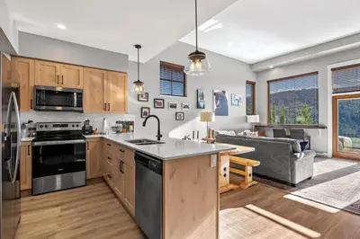 an open kitchen and living room with a couch at Powder Heights #15 home in Sun Peaks