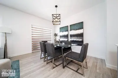 a dining room with a black table and chairs at Modern Executive Home-Sleeps12-KingBeds-FullHouse in Edmonton