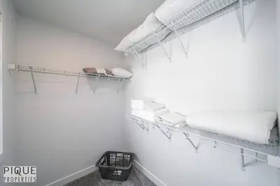 a white room with shelves and towels on a wall at Modern Executive Home-Sleeps12-KingBeds-FullHouse in Edmonton