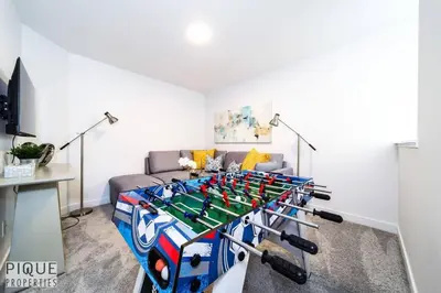 a ping pong table in a living room with a couch at Modern Executive Home-Sleeps12-KingBeds-FullHouse in Edmonton