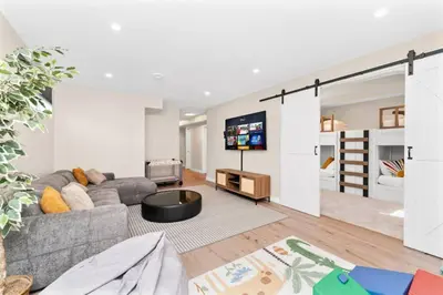 a living room with a couch and a tv at BunkBedDreams,10 Beds,Near Rogers place and Nait in Edmonton