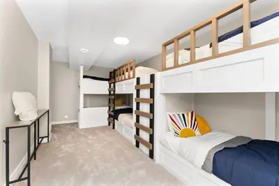 a bedroom with two bunk beds and a desk at BunkBedDreams,10 Beds,Near Rogers place and Nait in Edmonton