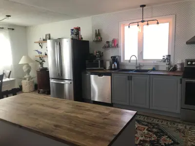 a kitchen with a stainless steel refrigerator and a window at Northern Rainbow Upper Level Suite in House in Yellowknife