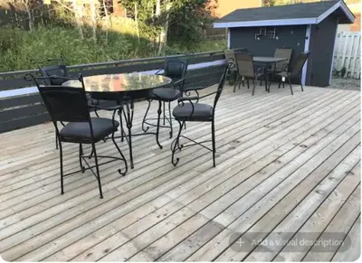 a patio with a table and chairs on a deck at Northern Rainbow Upper Level Suite in House in Yellowknife