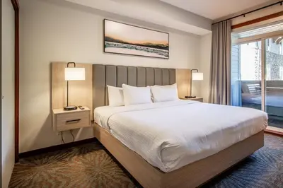 a hotel room with a large bed and a window at Premium King suite with views and pool in Canmore