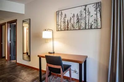 a desk with a chair and a lamp on a wall at Premium King suite with views and pool in Canmore