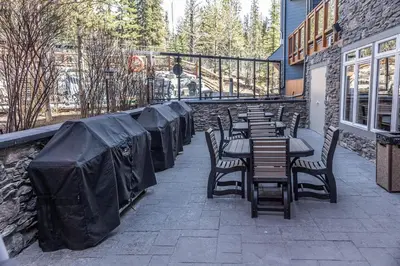 a row of tables and chairs on a patio at Premium King suite with views and pool in Canmore