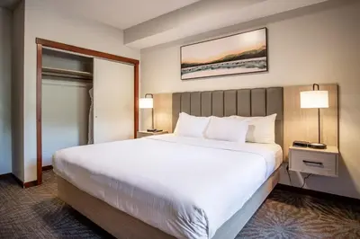 a hotel room with a large bed and two lamps at Premium King suite with views and pool in Canmore