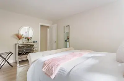 a white bedroom with a white bed and a mirror at The Oxford Signature Luxury Entire Family Suite in Coquitlam