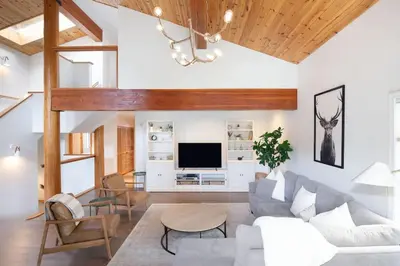 a living room with a couch and a tv at White Gold Chalet - Spacious Family-Friendly Chalet, Hot Tub, Mountain Views, Log Fireplace in Whistler