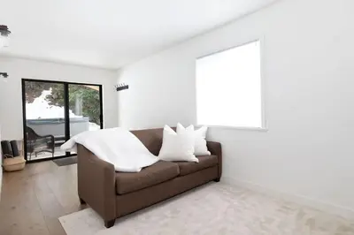 a living room with a brown couch with white pillows at White Gold Chalet - Spacious Family-Friendly Chalet, Hot Tub, Mountain Views, Log Fireplace in Whistler