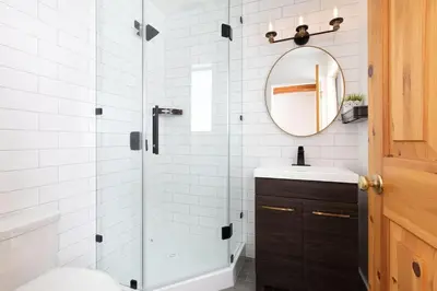 a bathroom with a shower and a sink and a mirror at White Gold Chalet - Spacious Family-Friendly Chalet, Hot Tub, Mountain Views, Log Fireplace in Whistler