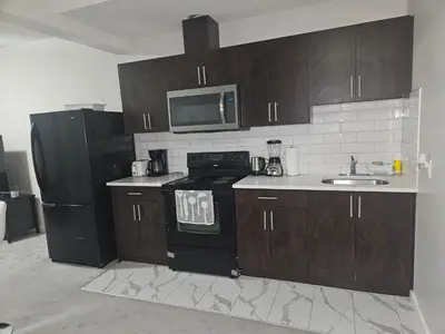 a kitchen with a black stove and a sink at Wola's Place in Calgary