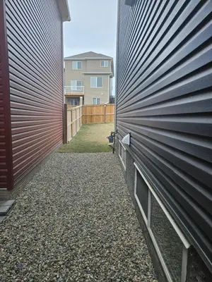 a retaining wall next to a house with a driveway at Wola's Place in Calgary