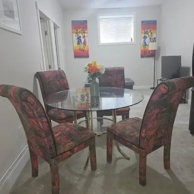 a dining room with a glass table and four chairs at Wola's Place in Calgary