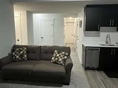 a living room with a couch and a kitchen at Arriva Homestay in Calgary