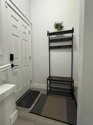 a hallway with a door with a shelf and a rug at Arriva Homestay in Calgary