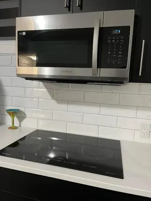 a microwave on a counter in a kitchen at Arriva Homestay in Calgary